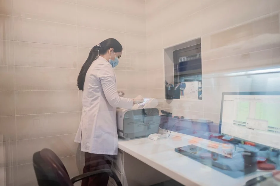 Person in PPE disinfecting indoor window area during COVID-19 pandemic.